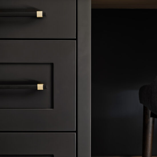 Close-up of a sleek black home office desk with gold hardware and oak countertop in Durham Region