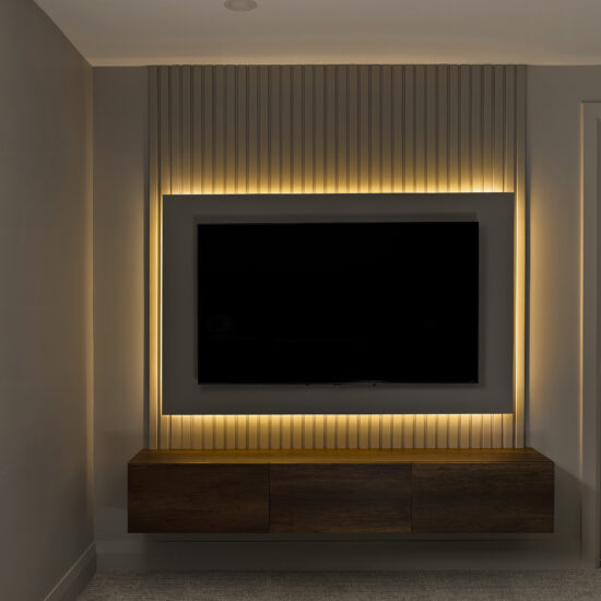 Modern media wall with built-in TV and LED accent lighting in a sleek Durham Region home.